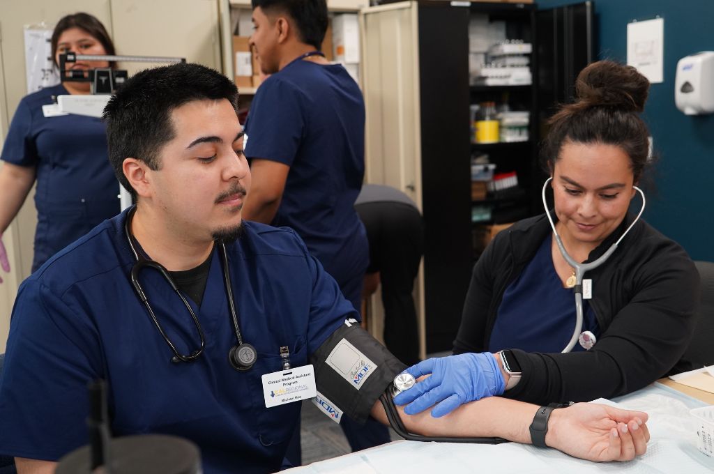CALRegional medical assistant student practicing how to take blood pressure during a hands-on clinical lab.