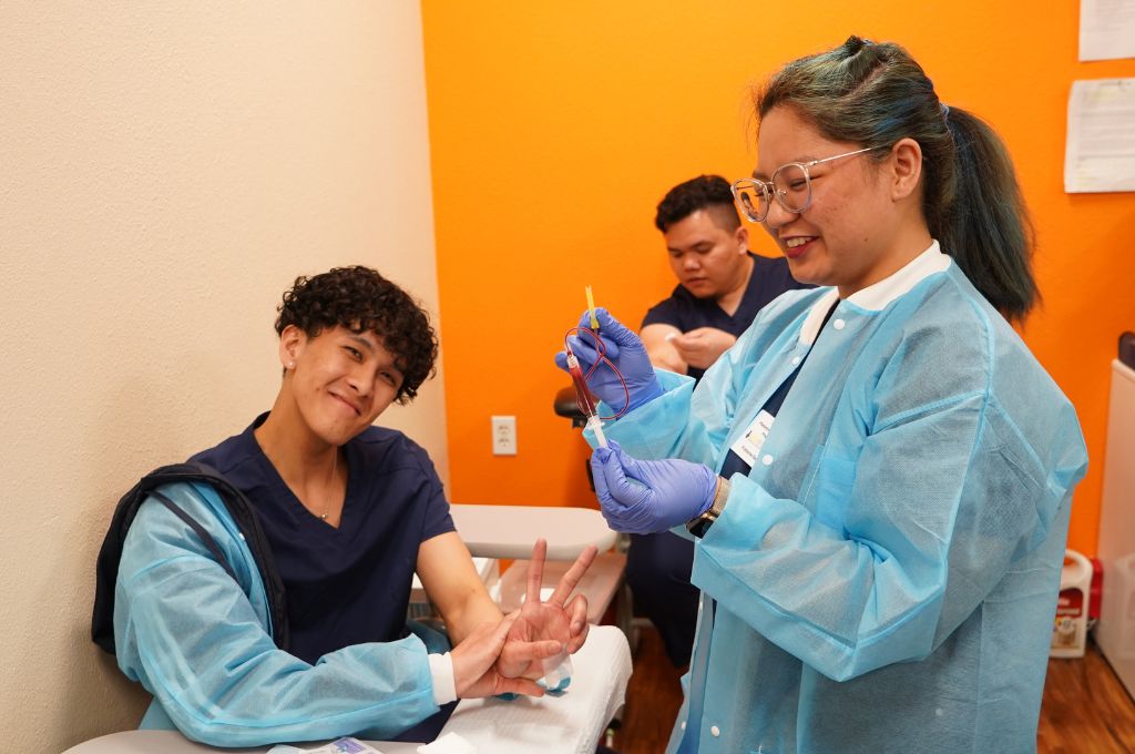 Phlebotomy students in Sacramento practicing blood draw techniques during CALRegional training.