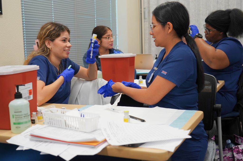 Medical assistant students at a Monterey County vocational school practicing lab skills.