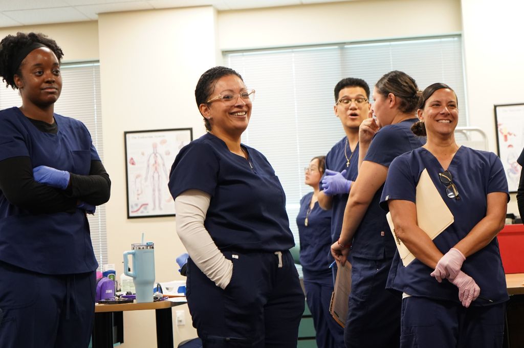 San Jose medical assistant students smiling in class during hands-on training.