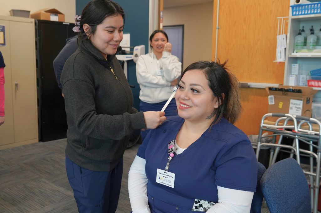 Student practicing hands-on medical assistant skills during clinical training in Bloomington, California